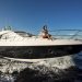A person enjoying a sunny day on a sleek yacht cruising through blue waters.