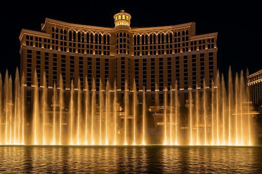 Bellagio Fountains illuminated in front of the hotel at night