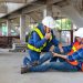 Asian factory workers having accident while working in manufacturing site while his colleague is helping for safety workplace and emergency
