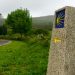 A stone waymark with a yellow scallop shell on the Camino de Santiago hiking trail