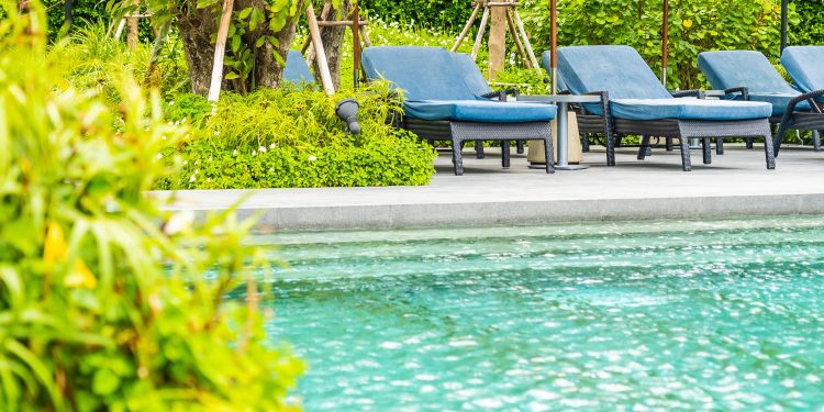 Beautiful outdoor swimming pool in hotel and resort with chair and deck for leisure vacation and travel