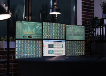 Empty interior of forex market exchange company office with financial data and growth charts on multiple displays. Workspace equipped with workstation having finance statistics and real time graph.