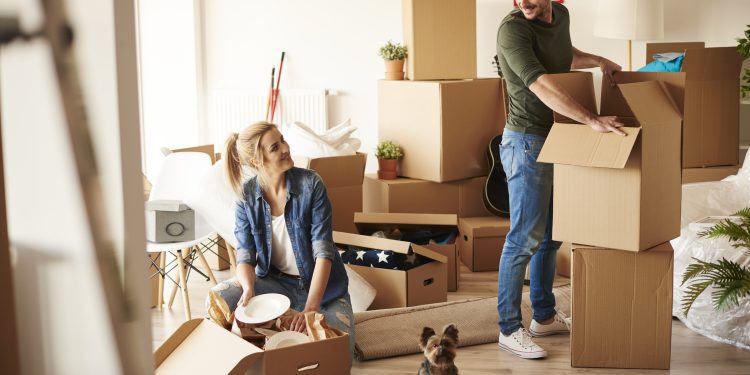 Young couple in new apartment with small dog