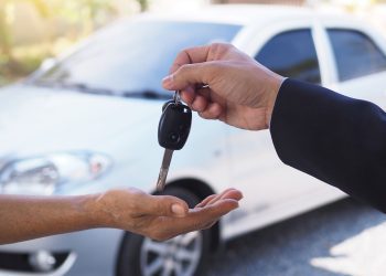 The car salesman and the key to the new owner.