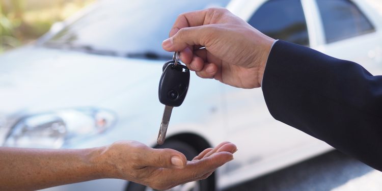 The car salesman and the key to the new owner.