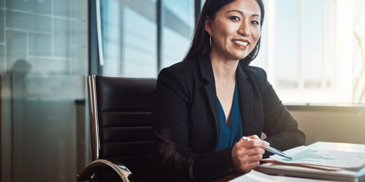 Asian woman, portrait and documents with charts, smile and review for financial data at agency. Risk analyst, person or happy with paperwork, stats or info on graphs for business growth in Jakarta.