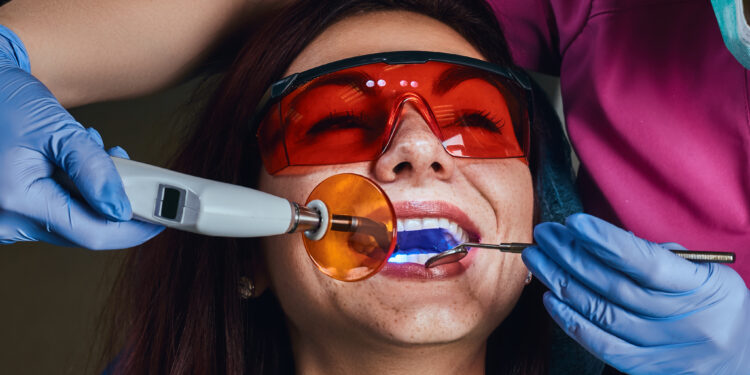 Female dentist treating a patient. Close-up photo of a young woman sitting in the dentist's chair.