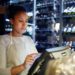 Pretty young cashier registrating orders of clients of cafe, bar or restaurant