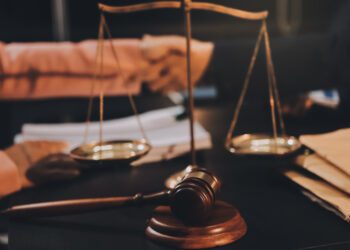 Judge gavel with Justice lawyers having team meeting at law firm background. Concepts of Law and Legal services.