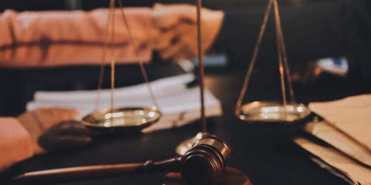 Judge gavel with Justice lawyers having team meeting at law firm background. Concepts of Law and Legal services.