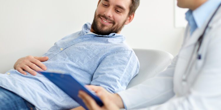 medicine, healthcare and people concept - doctor with clipboard and smiling young male patient at medical exam at hospital