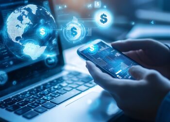 A person using their smartphone to create an online marketing campaign. The screen displays a floating globe and money icons above the phone screen on one side of it. The background is blurred with soft lighting, highlighting details like a laptop keyboard or office setting, symbolizing digital marketing technology in a business work environment. --ar 3:2 --q 2 - Image #2 @Hasnain Muavia