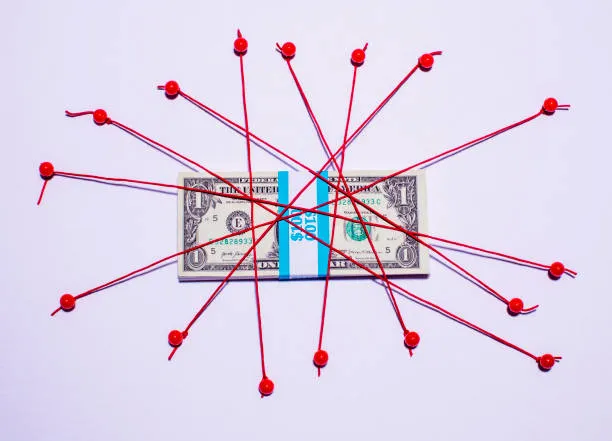Wealth protection concept showing a dollar bill surrounded by red strings symbolizing financial risk and capital exposure.