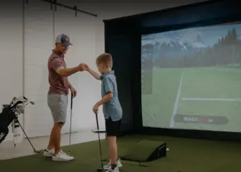 Father and son indoor golf simulator.