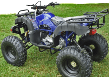 Blue ATV parked on green grass.