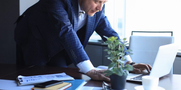Elegant mature businessman analyzing data while working in office