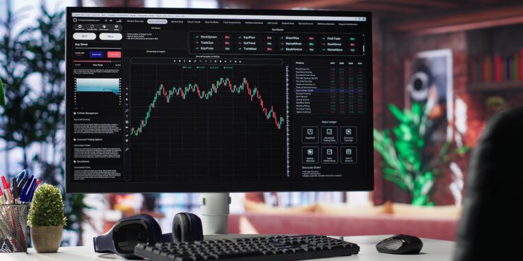 Empty workspace desktop running day trading stock market trends in stylish apartment. PC used for monitoring investment numbers and candle stick charts, a comfortable environment.