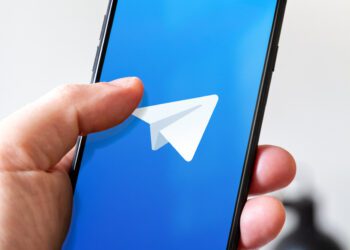 Paris - France - March 23, 2021 : Hand holding iphone smartphone with Telegram logo