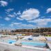 A horizontal shot of a construction site with scaffolding under the clear blue sky