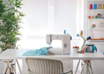 Sewing machine with fabric on table in tailor workshop