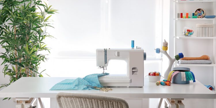 Sewing machine with fabric on table in tailor workshop