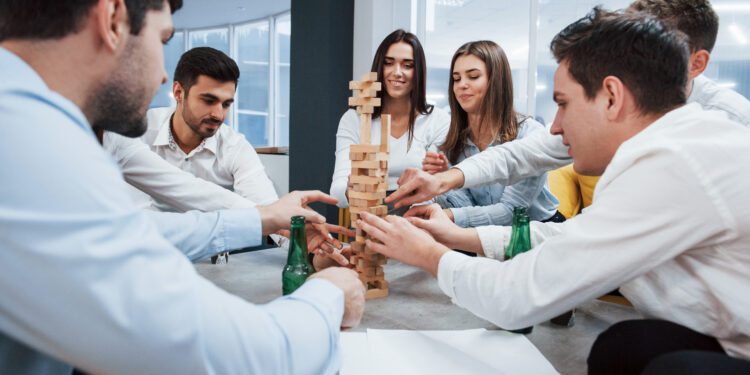 It's almost fall of. Celebrating successful deal. Young office workers sitting near the table with alcohol.