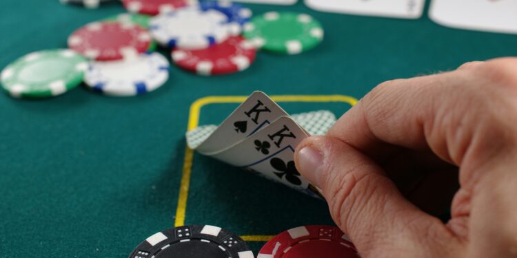 Person holding a hand of black and white playing cards, focused on the cards in their hand