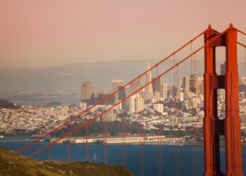 San Francisco cityscape with the Golden Gate Bridge tower in the foreground during sunset, USA