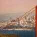 San Francisco cityscape with the Golden Gate Bridge tower in the foreground during sunset, USA