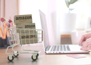 Boxes in shopping cart near the laptop. Editorial 3D