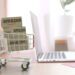 Boxes in shopping cart near the laptop. Editorial 3D