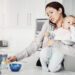 Its always a rush in the morning. an overwhelmed mother trying to multitask while holding her baby boy