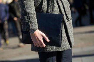 MILAN, ITALY - JANUARY 16: Phil Green of Farfetch wears Acquasutum coat Whistles trousers, a Tudor watch, and black portfolio clutch at Milan Men's Fashion Week Fall/Winter 2016/17 on January 16, 2016 in Milan, Italy. (Photo by Melodie Jeng/Getty Images)