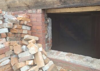 Brick wall and basement opening in a residential building, an illustrative property-condition photo
