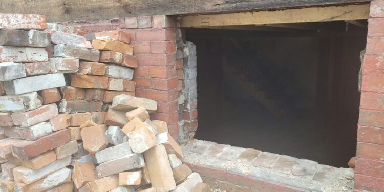 Brick wall and basement opening in a residential building, an illustrative property-condition photo