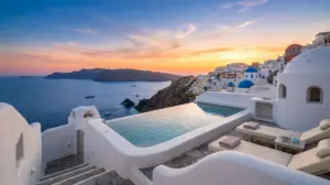 Whitewashed cave suite with infinity pool overlooking the Santorini caldera at sunset, Greece